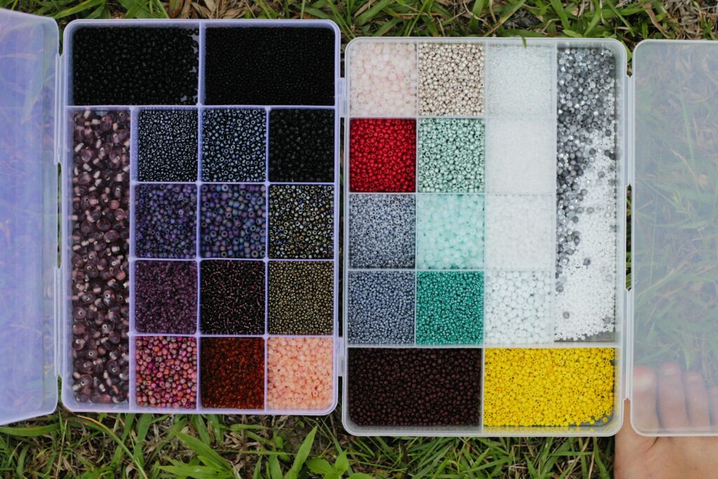 a person is holding a box of seed beads